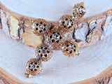 gold plated cross brooch with black and white stones