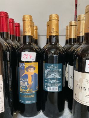 de nombreuses bouteilles de vin sur une étagère dans un magasin