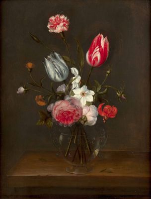 flowers in a glass vase on a table with a dark background