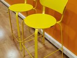 two yellow stools sitting next to each other on a wooden floor