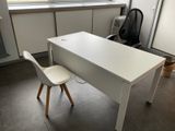 a white desk with a chair and a window in the background