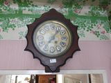 une horloge accrochée au mur au-dessus d'un miroir dans une pièce