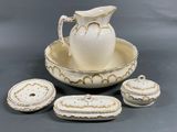 a white and gold plate with a pitcher and a bowl