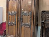 une grande armoire en bois dans une pièce où se trouve une chaise rouge