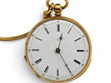 a gold pocket watch with roman numerals on the face