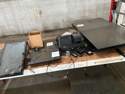 several laptops are sitting on a table in a warehouse