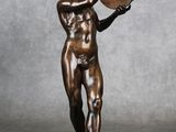 statue en bronze représentant un homme tenant un bol, posée sur un socle