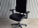 an image of a black office chair in front of a corrugated wall