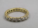 un gros plan d'une bague en or et diamants posée sur une table