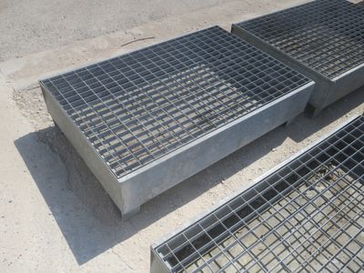 deux grilles métalliques posées à même le sol, l'une à côté de l'autre