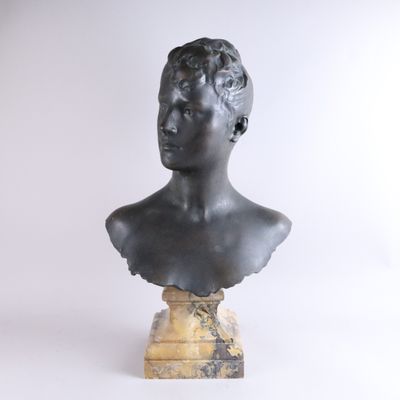 une image représentant un buste en bronze d'un garçon posé sur un socle en marbre