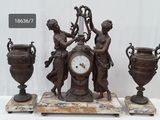 une horloge posée sur une table à côté de deux vases