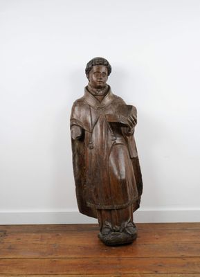 Statue de Saint en bois sculpté tenant un livre ouvert dans …