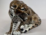 a figurine of a leopard sitting on the ground
