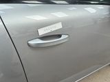 a silver car with a sticker on the door handle