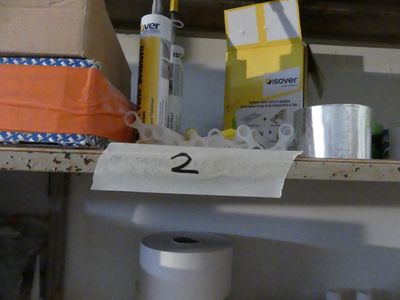 deux rouleaux de papier toilette sur une étagère, à côté d'un rouleau de papier toilette