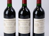 trois bouteilles de vin rouge posées l'une à côté de l'autre sur une surface blanche