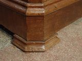 a close up of a wooden bed with a clock on it