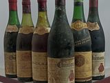 several bottles of wine are lined up on a metal stand