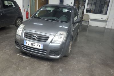 une voiture argentée garée dans un garage à côté d'une voiture noire