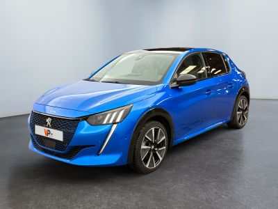 La voiture bleue est garée dans une pièce au sol noir.
