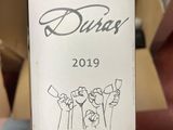 someone is holding a bottle of wine with a drawing on it