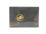 black and gold business card holder with a gold coin on top of it