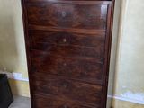 a wooden chest of drawers in the corner of a room