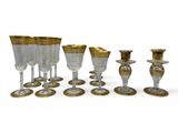 a group of wine glasses and a candle holder on the table