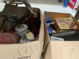 deux cartons remplis d'objets, posés par terre