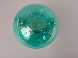 a green glass ball with a face inside of it