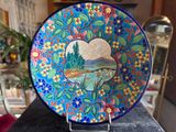 a close up of a decorative plate on a stand on a table