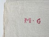 an image of a close up of a piece of cloth with a red cross stitching on it