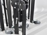 a group of black metal poles with wheels on a white surface