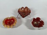 three pieces of glass sitting on top of a table next to each other