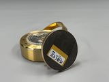 une montre dorée et noire posée sur une surface blanche