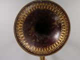 someone is holding a brass plate with a decorative design on it