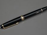 le stylo est posé sur la table, à côté du verre