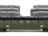 three green train cars sitting next to each other on a white surface