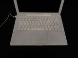 a white laptop computer sitting on top of a black table