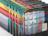 brightly colored glass boxes stacked on top of each other on a white surface