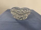 a clear glass bowl sitting on top of a blue cloth