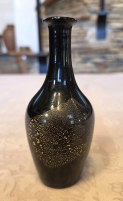 un vase noir posé sur une table dans une pièce