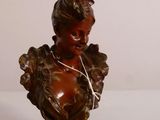 une petite statue représentant une femme avec un oiseau sur la tête
