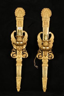 pair of antique brass wall sconces on black background