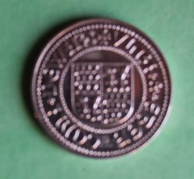a silver coin with a picture of a coat of arms on it
