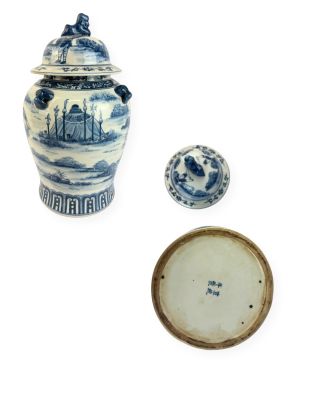 un vase bleu et blanc muni d'un couvercle, à côté d'un petit bol
