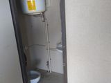 a small bathroom with a toilet and a water heater