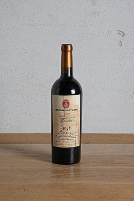 a bottle of red wine sitting on a wooden table