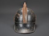 an old helmet with a wooden handle on a gray background
